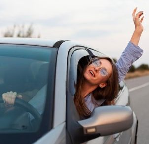 front view woman driving having fun_23 2148691783 1 e1742371618749
