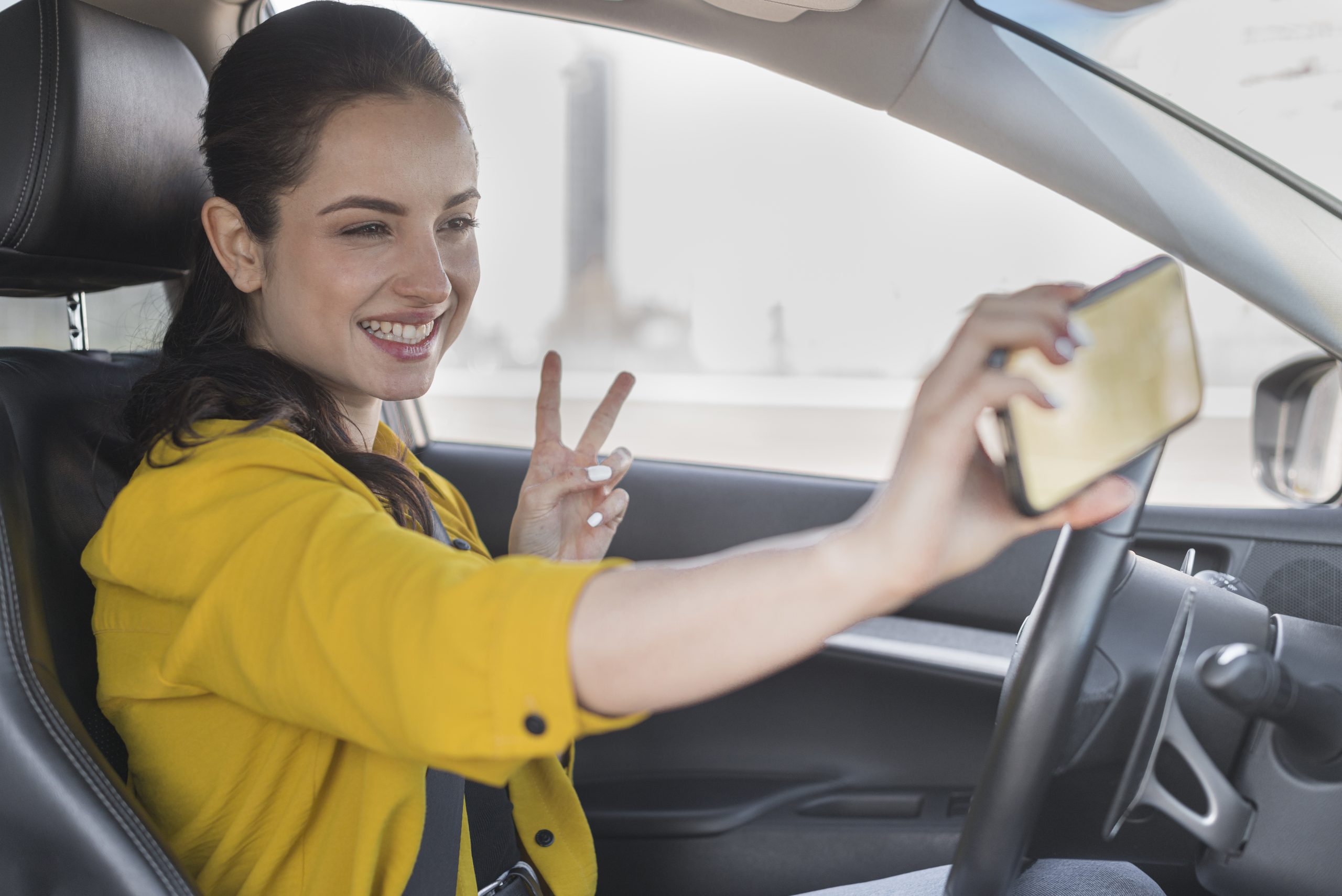 woman taking selfie car scaled